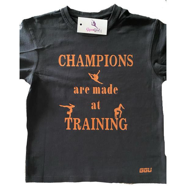 Black T-Shirt with Brinze foil print. The print read Champions are made at training. small gymnast silhouettes on T-Shirt.